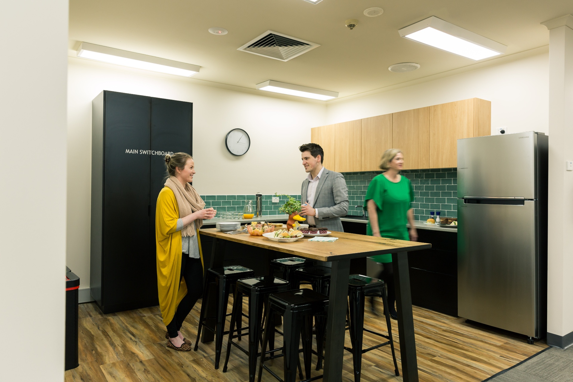 Members networking over coffee in a workspace kitchen